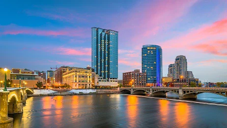 The downtown skyline on the Grand River in Grand Rapids, Michigan at dusk.