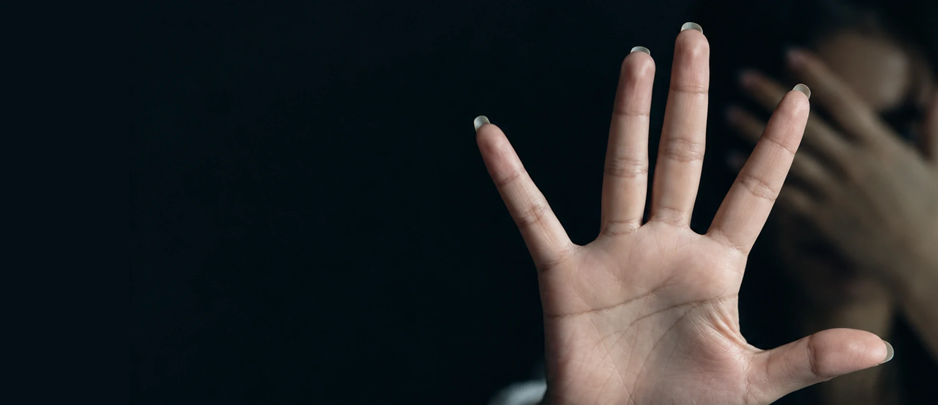 A victim of sexual abuse shielding her face